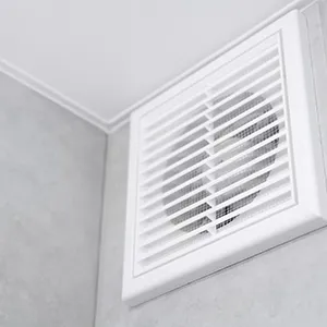 A bathroom with a white ceiling fan and a white wall.